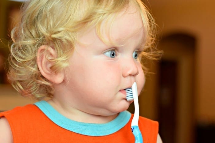 baby brushing with orajel toothbrush