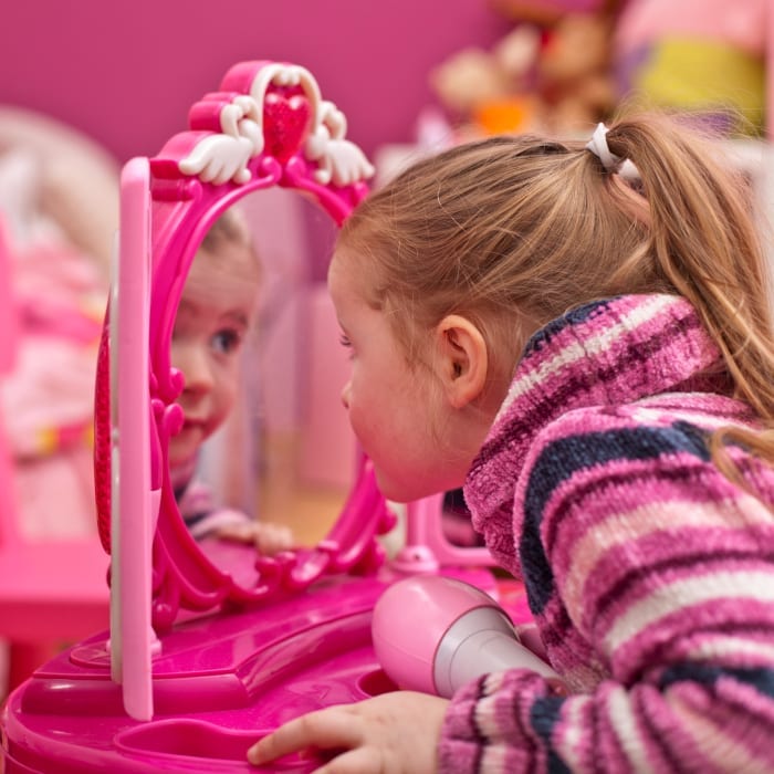 little girl looking in a mirror