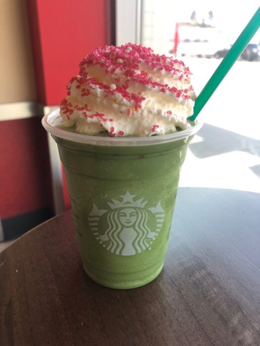 a matcha green tea frappuccino with peppermint topped with whipped cream and red sugar