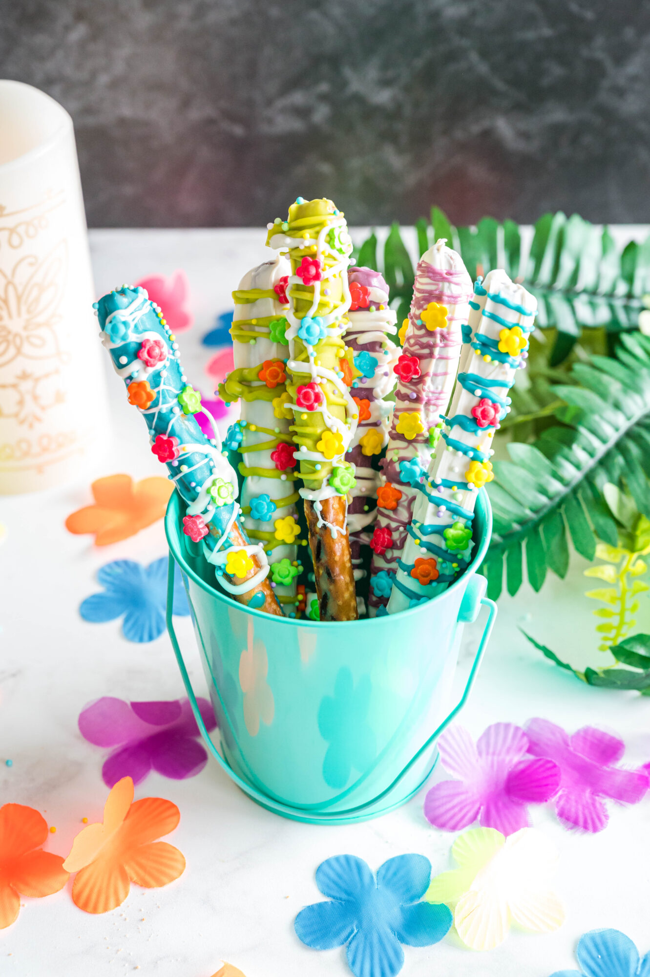 encanto chocolate dipped pretzel rods in a blue cup