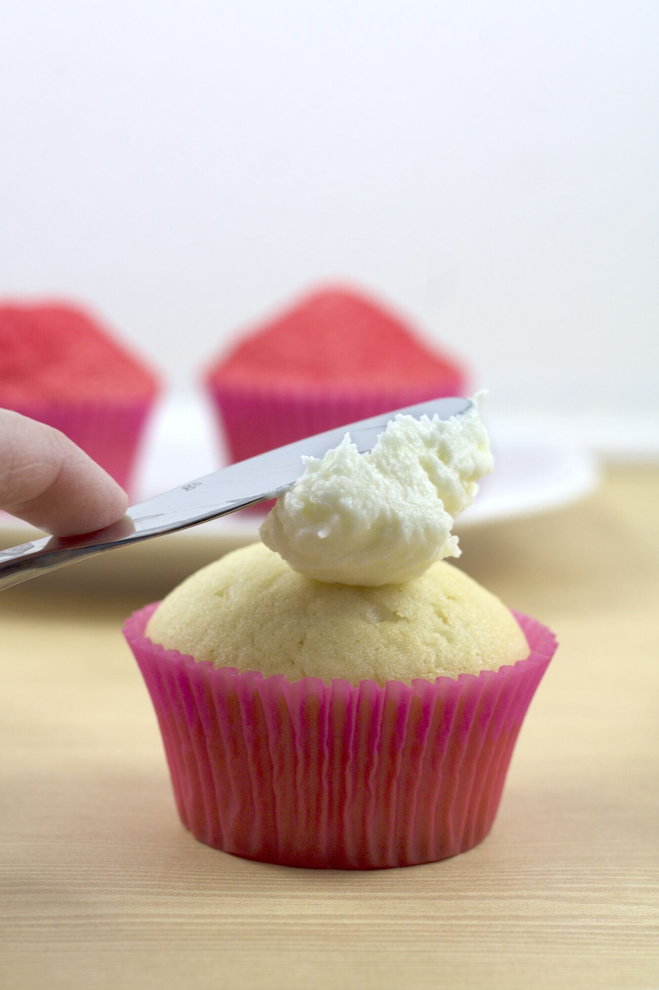 hand frosting top of snow cone cupcake