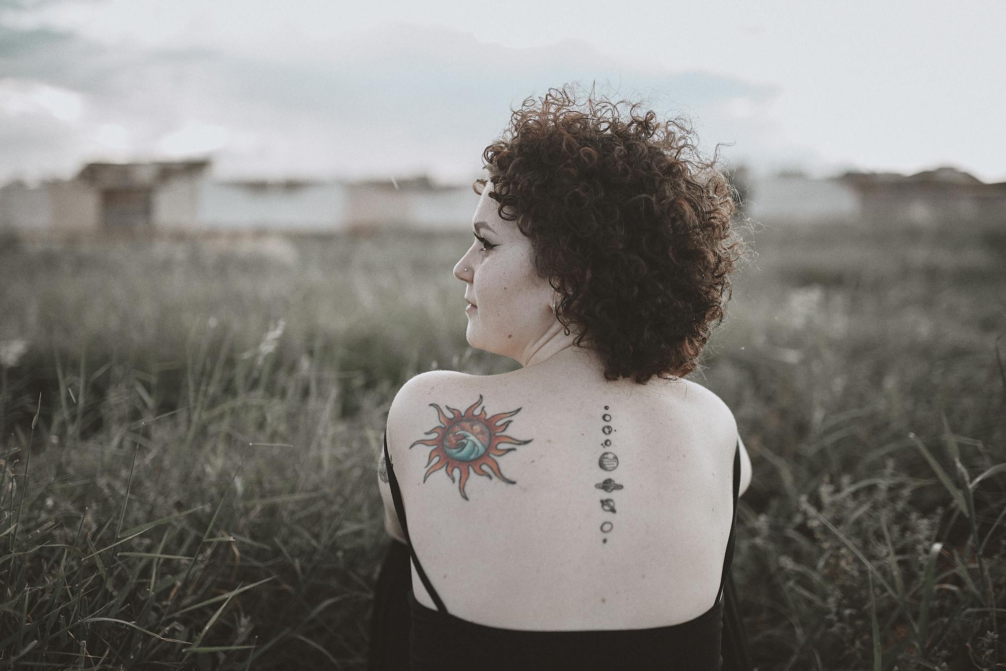 Woman Sitting On Green Grass Field