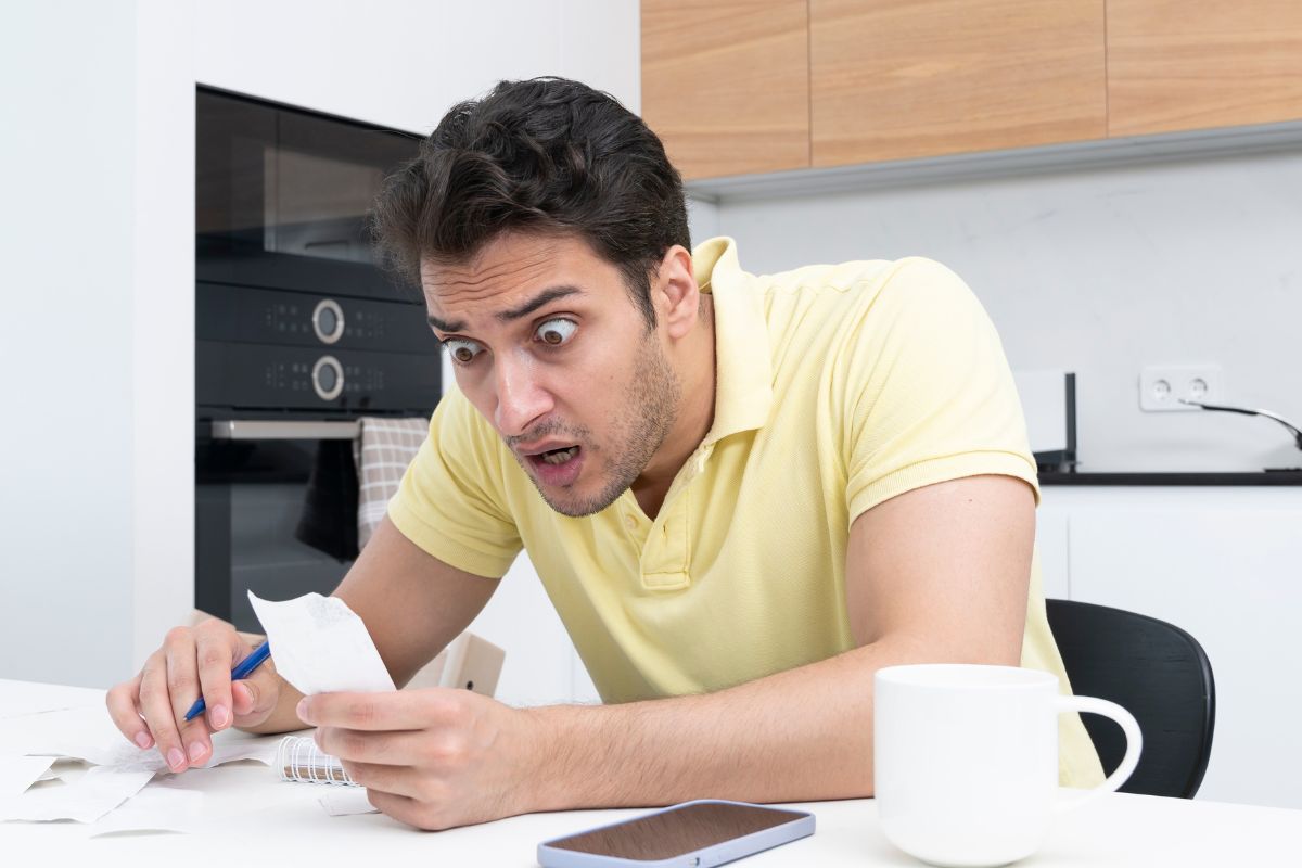 Man looking shocked at his bills