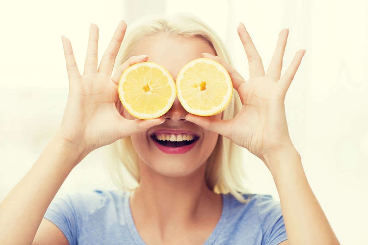 Woman with two lemon halfs up to her eyes