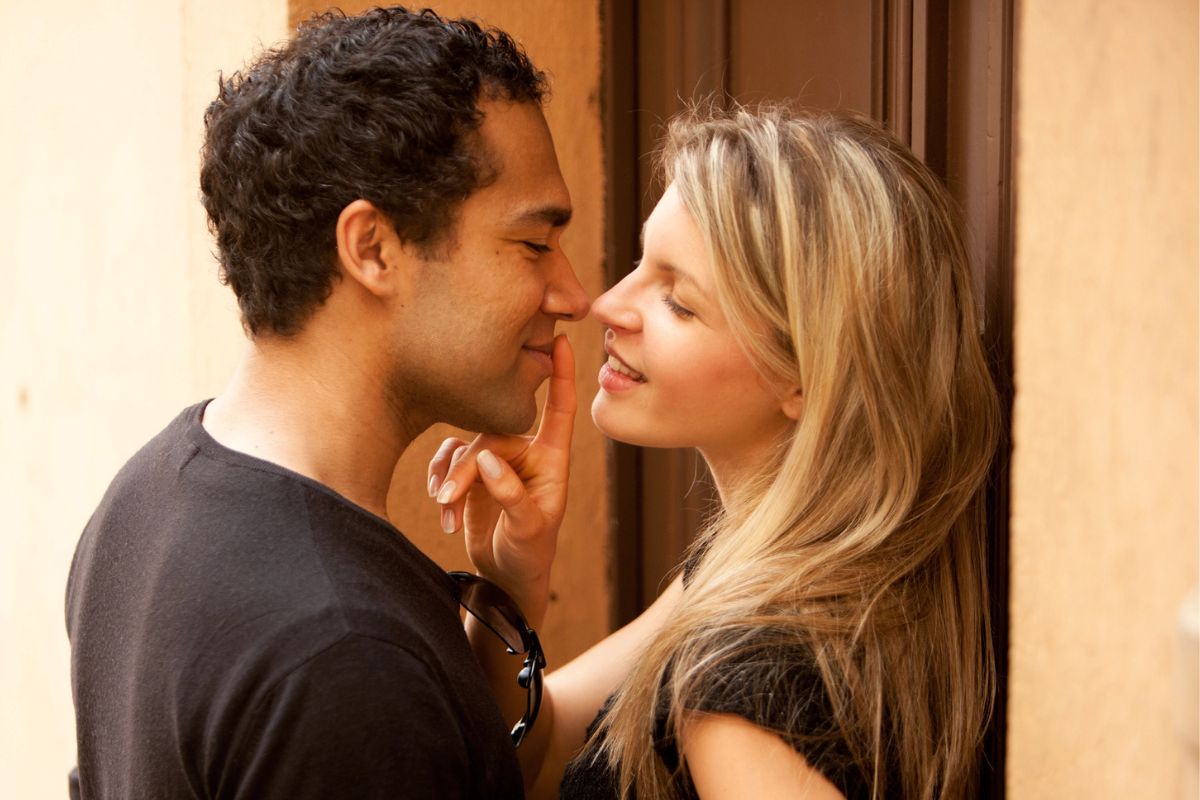girl holdling a mans lips with her finger .