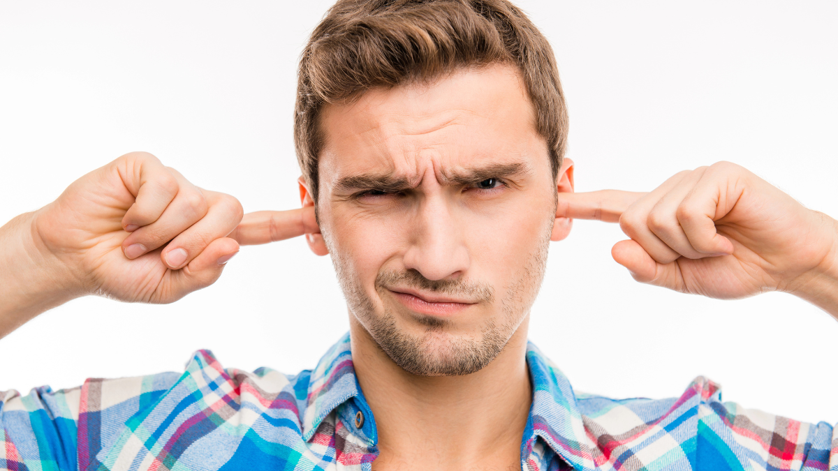 man plugging ears