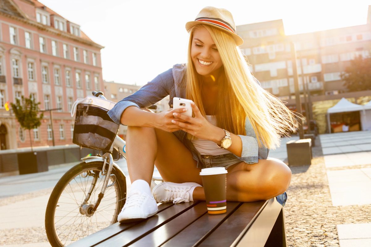stylish woman on her phone on a street bench
