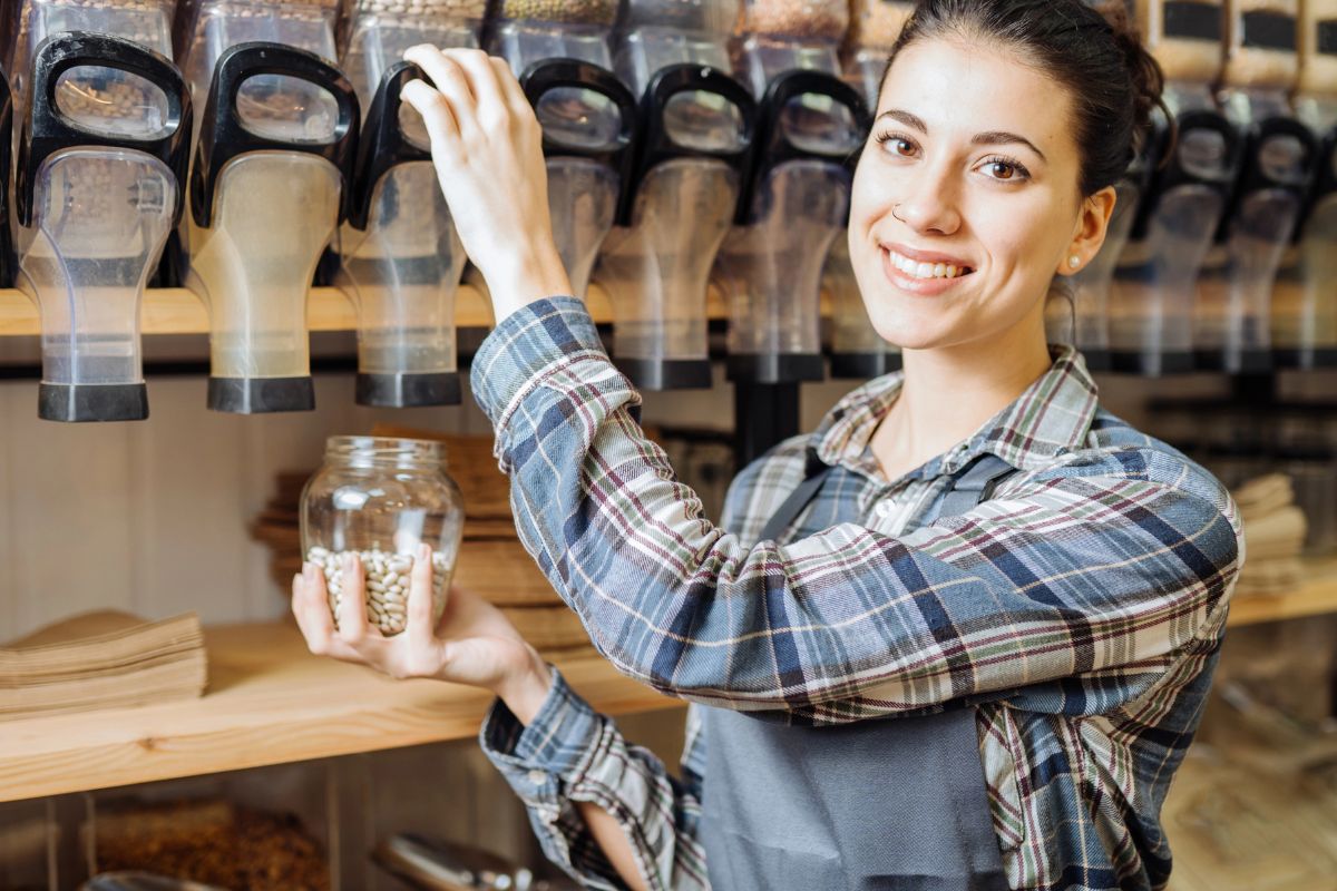woman filling a glass jar at a bulk store