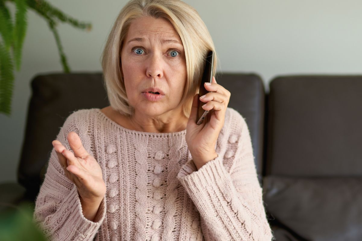 woman on the phone looking surprised and confused
