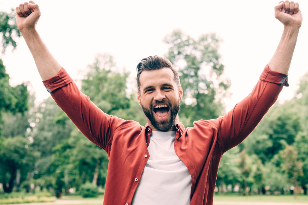 Happy man arms in the air outside
