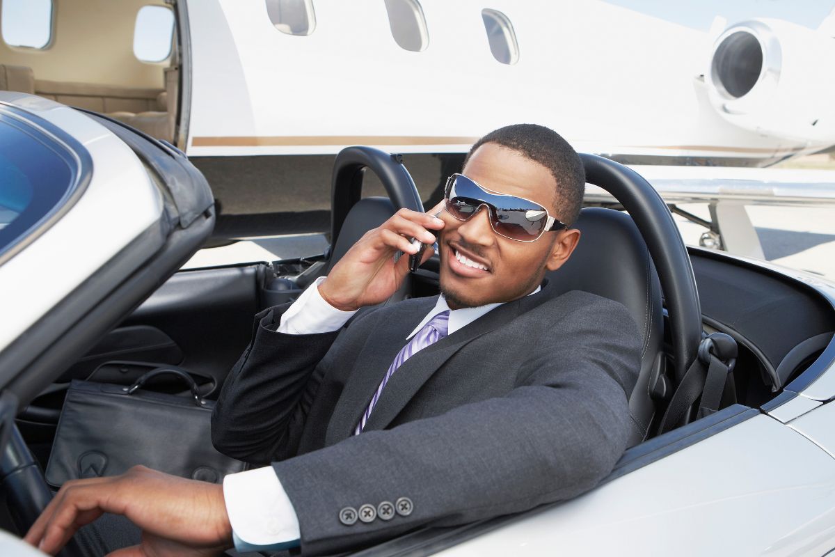 Man by a private jet in a nice car