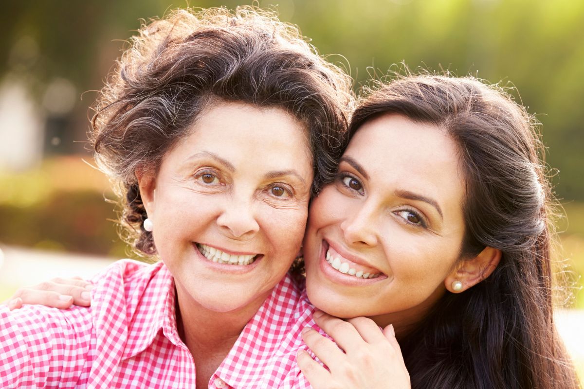 Mother and daughter smiling outside