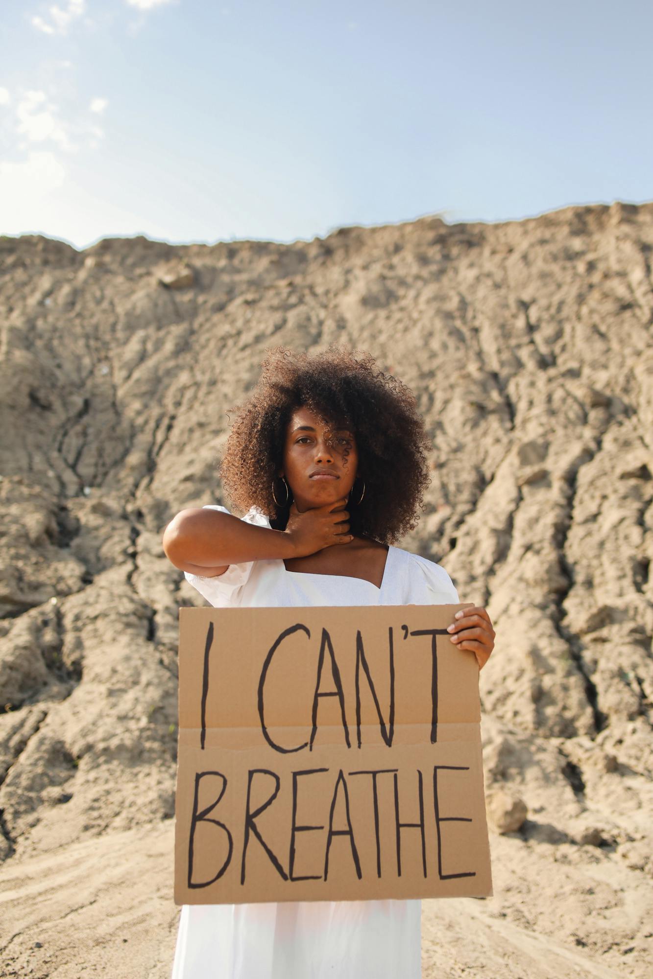 A Woman Choking Her Neck while Holding a Cardboard