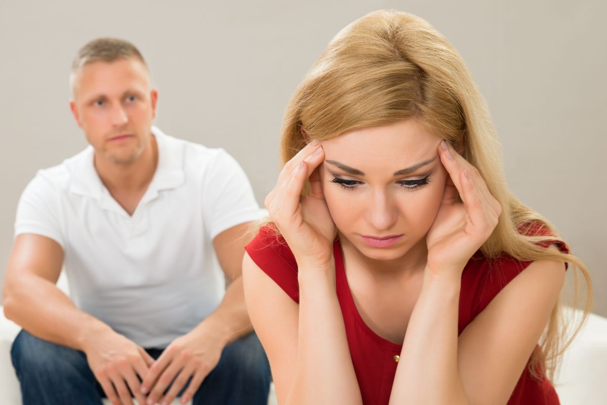 unhappy couple, woman holding the side of her head thinking
