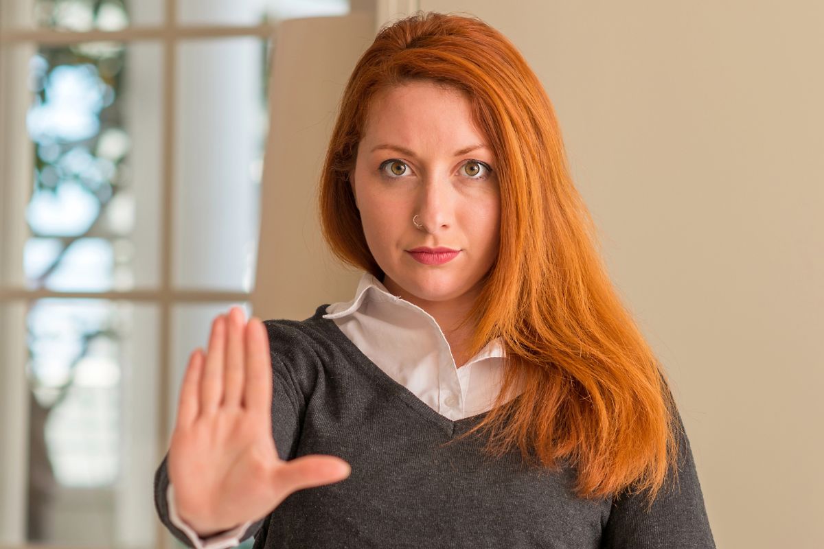 woman holding her hand up to say no
