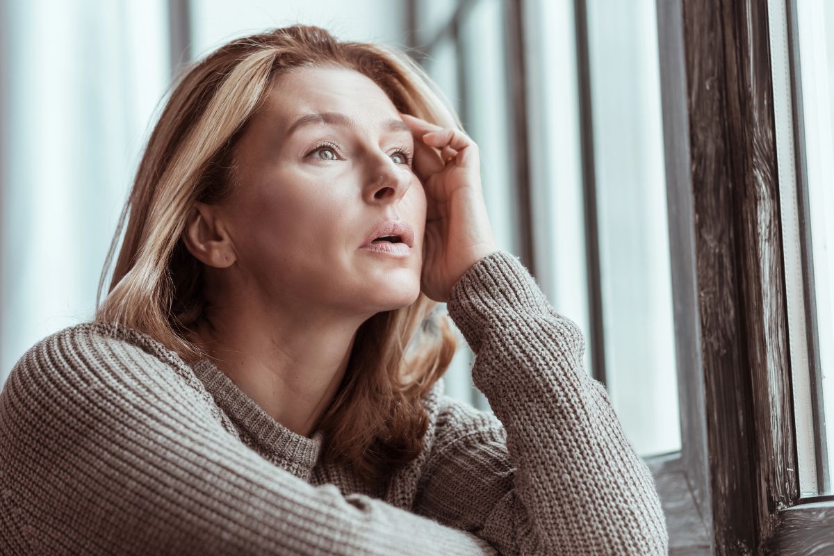 woman looking nervous by a window