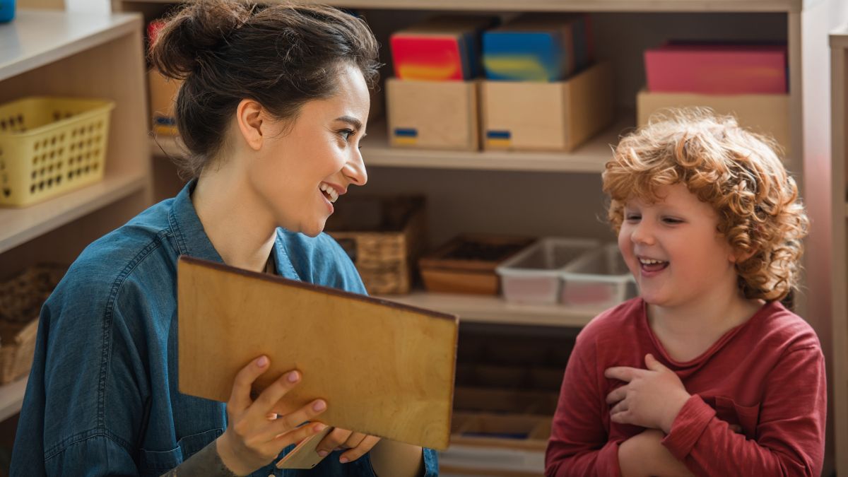 child working with teacher on board