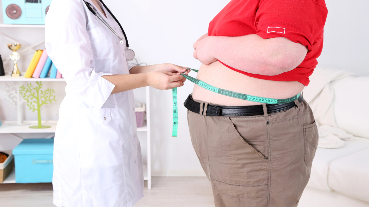 doctor measuring man's stomach