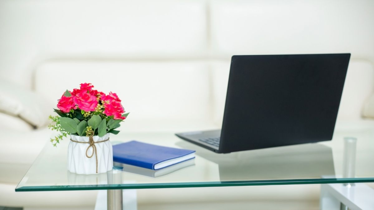 glass coffee table with computer and flowers