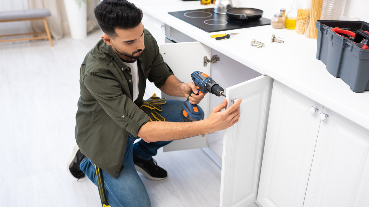 man installing new cabinet handles
