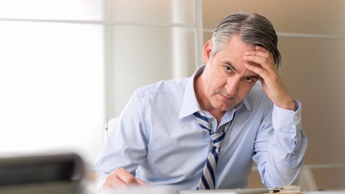 man looking stressed at desk