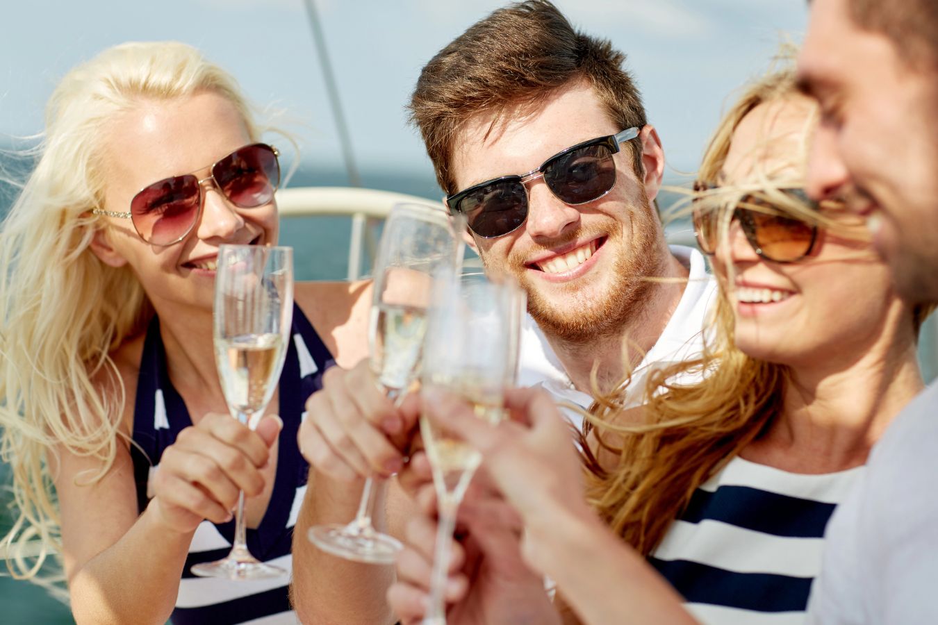 two men and two women cheersing on a boat
