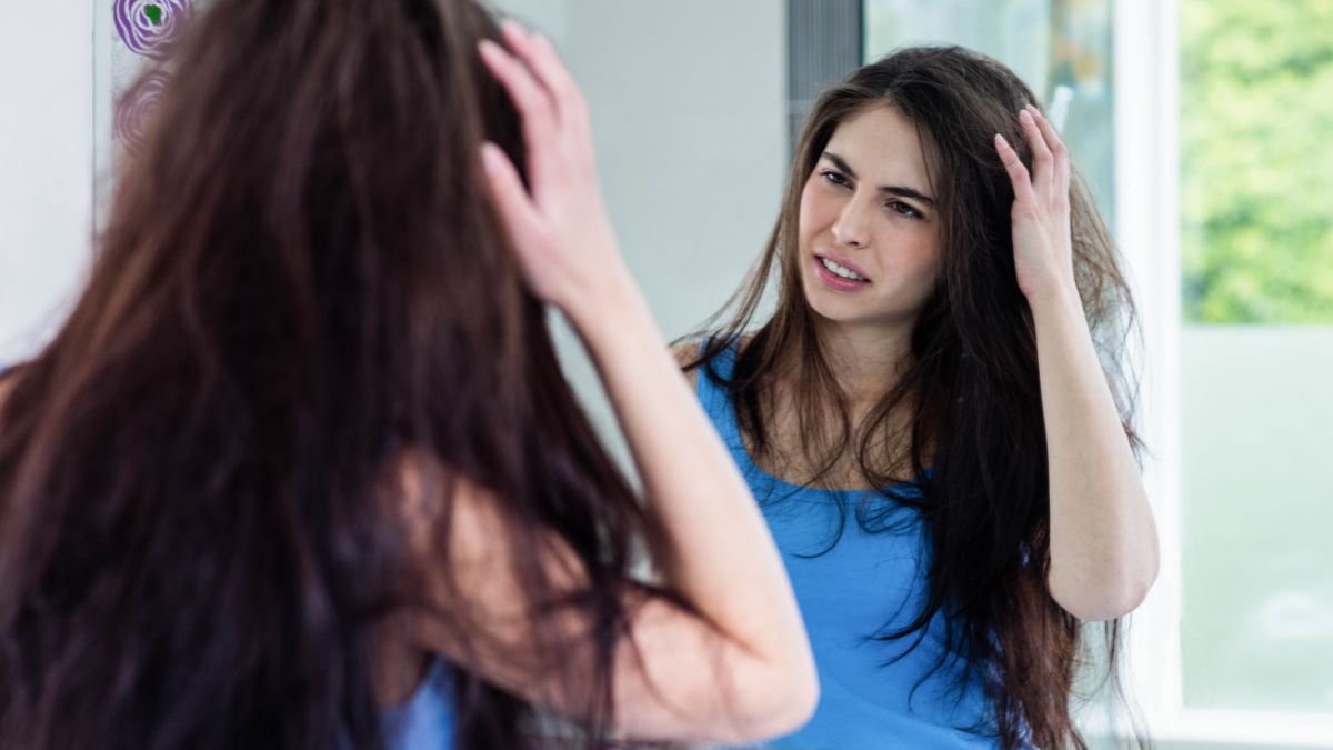 unhappy woman looking at messy hair