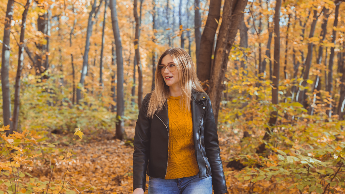 woman in sunglasses, jacket, and sweater
