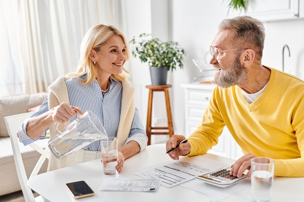 couple looking at bills happily at the table