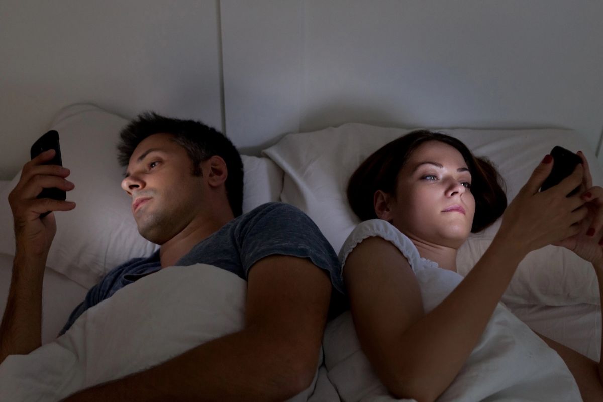 A couple in bed on their phones