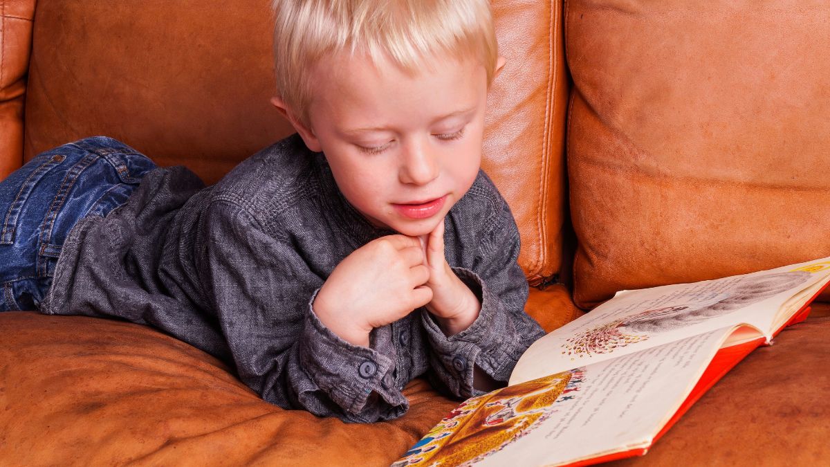 boy laying and reading on couch
