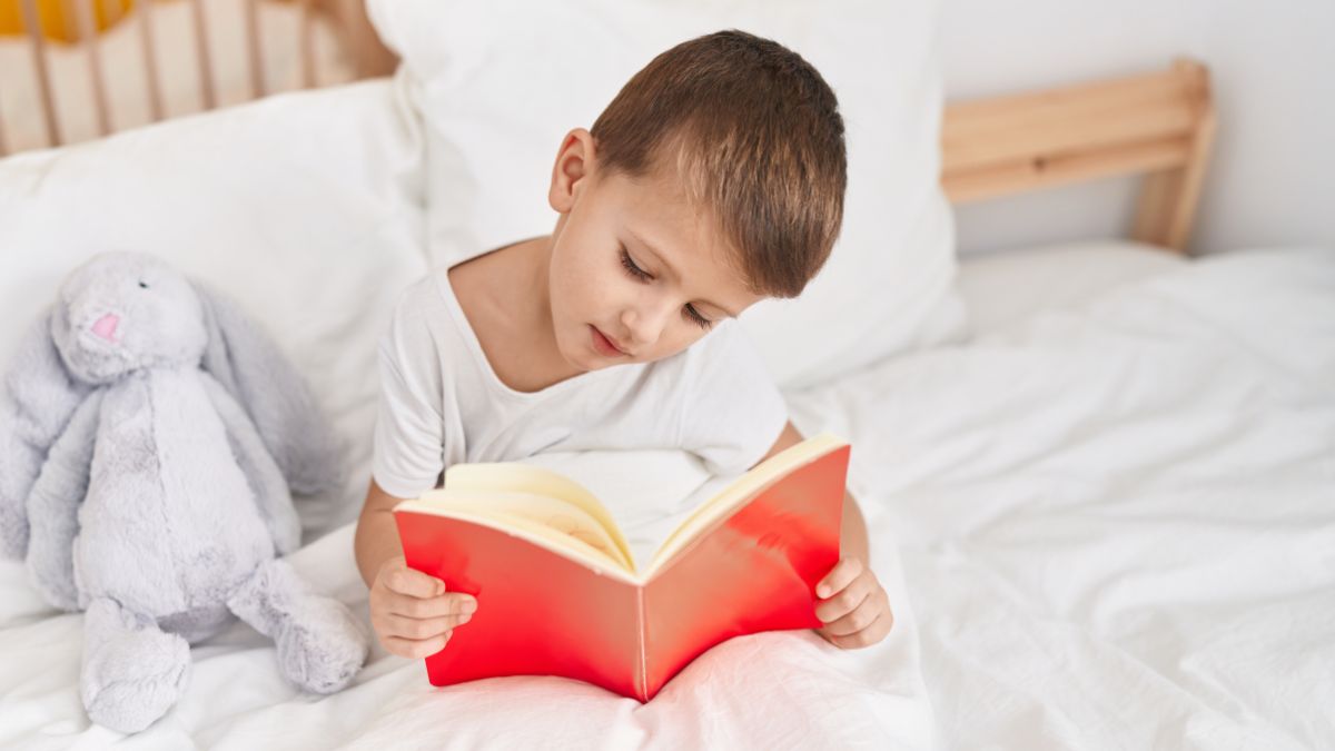 boy reading with stuffed rabbit