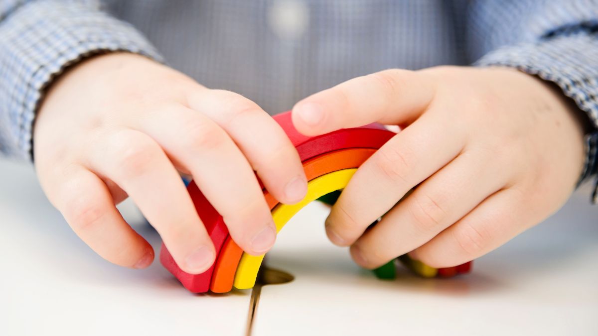child with rainbow toy