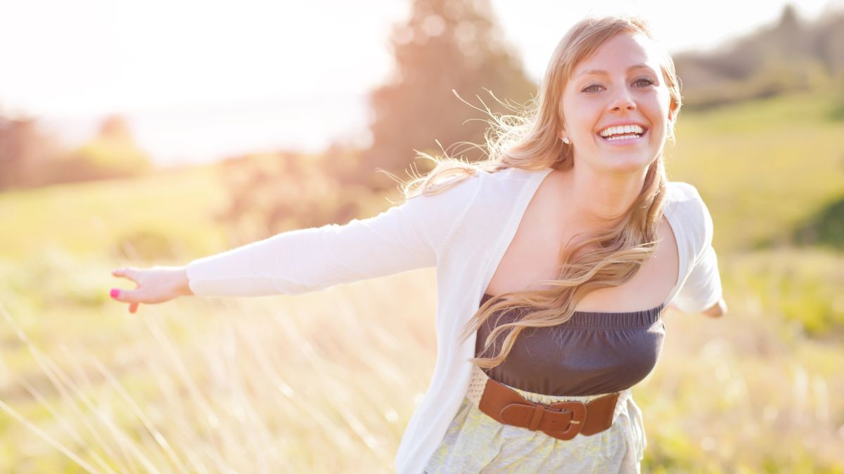 happy woman outside with arms up