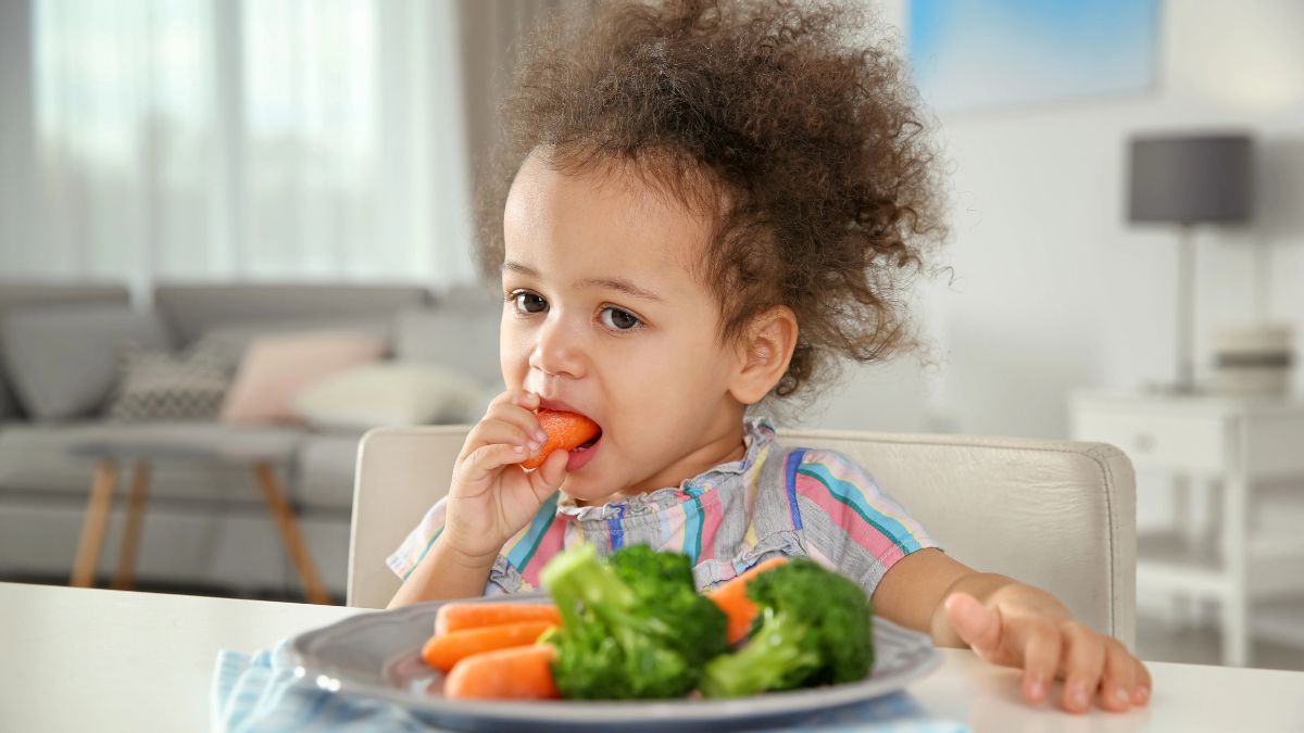 little girl eating vegetables