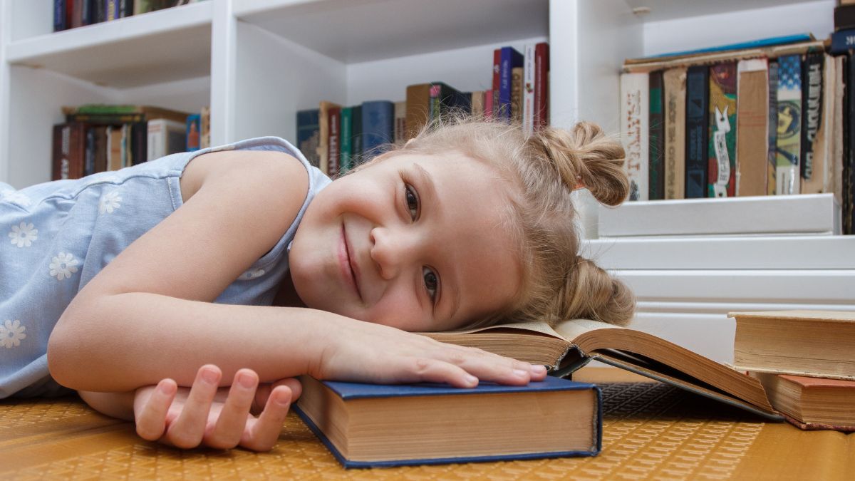 little girl smiling on a book