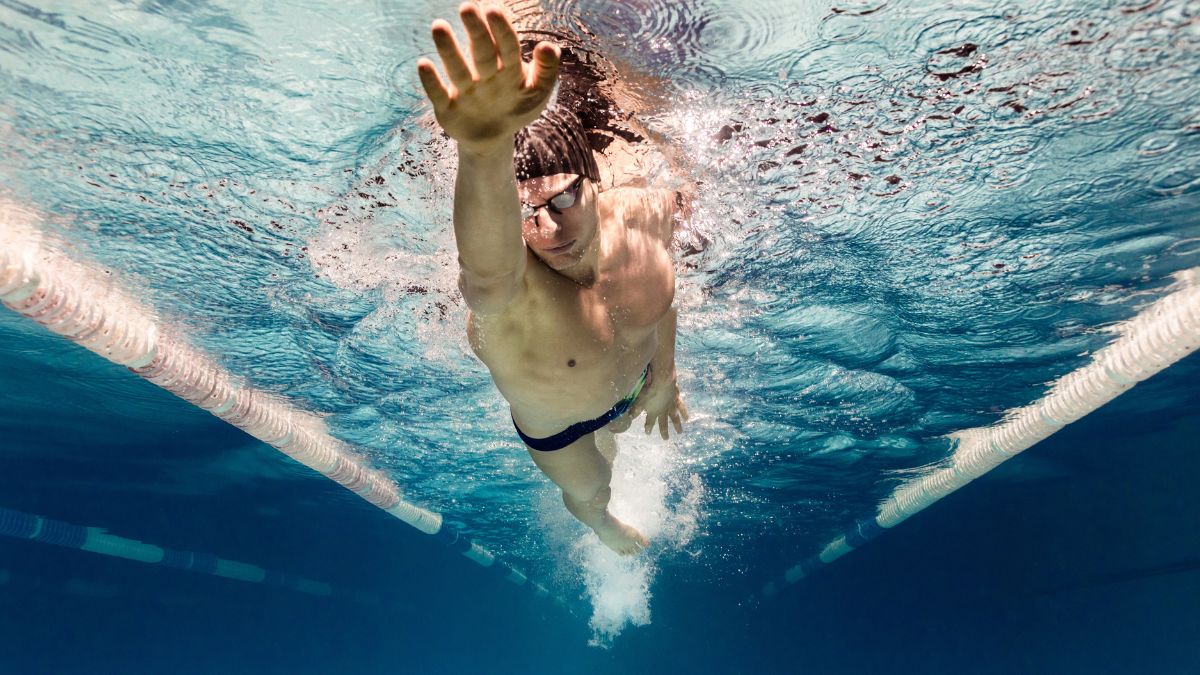 man swimming freestyle alone