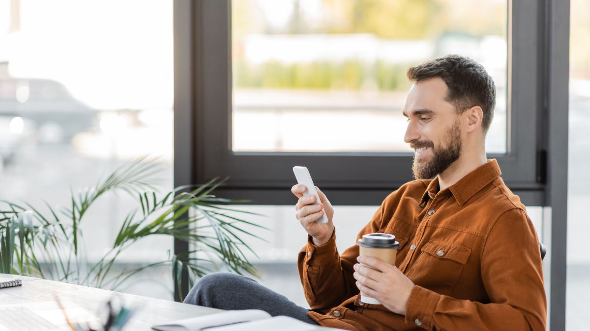 man with coffee on phone