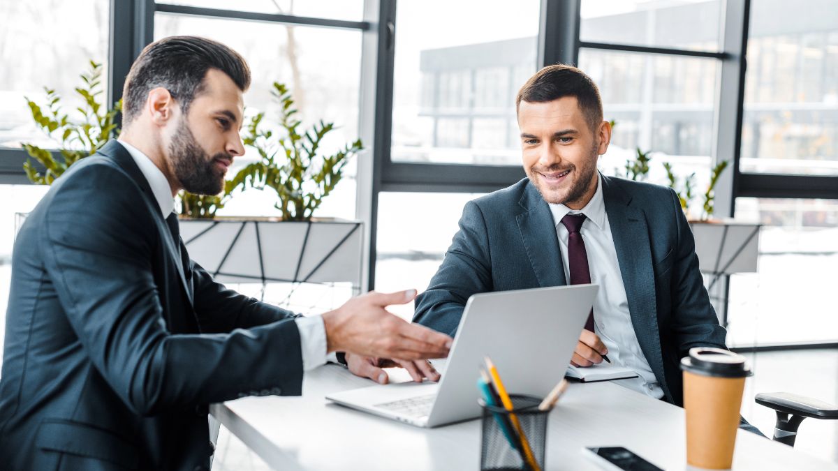men talking at computer at work