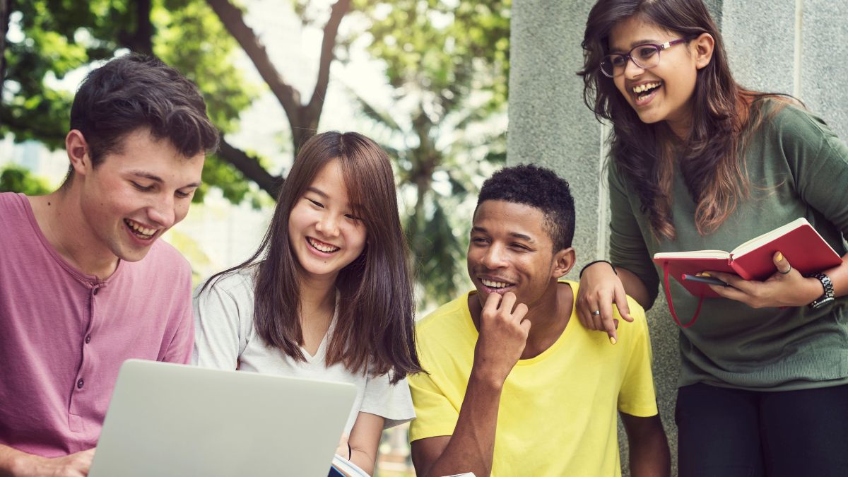 teens reading together with computer