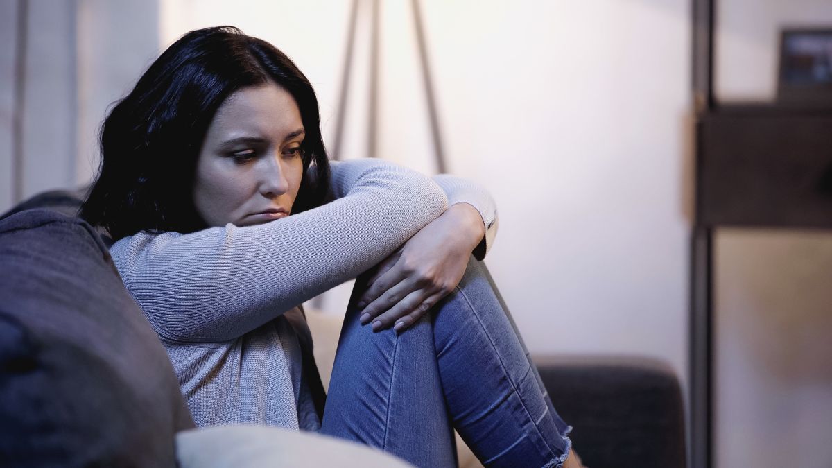 upset woman living alone on couch