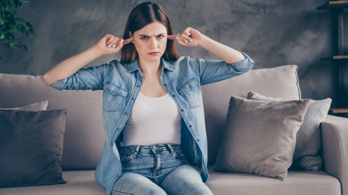 upset woman with fingers in ears