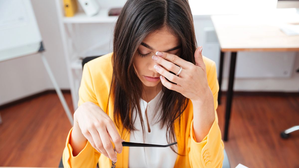 woman at desk looking stressed