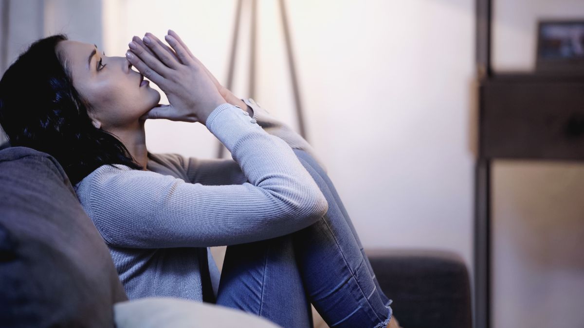 woman looking worried on the couch