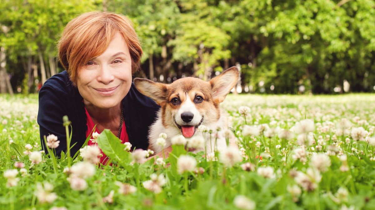 woman with dog in grass