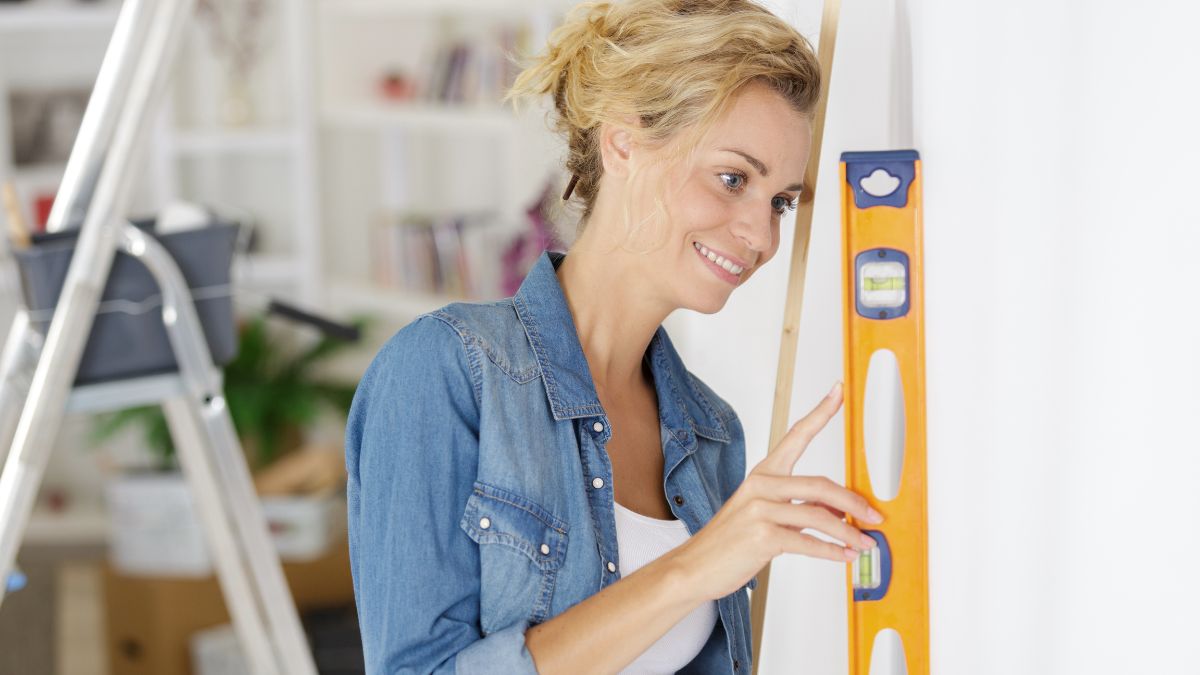 woman with level doing DIY