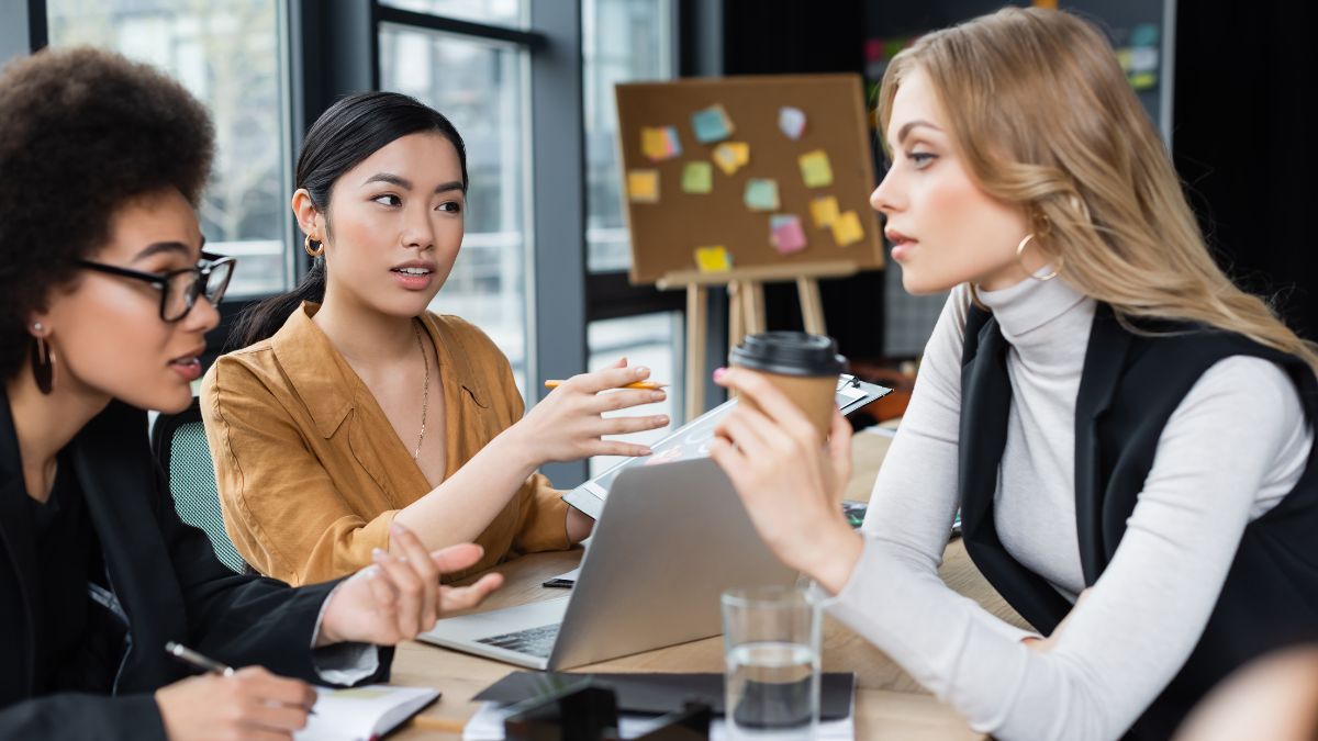 women talking with coffee at work