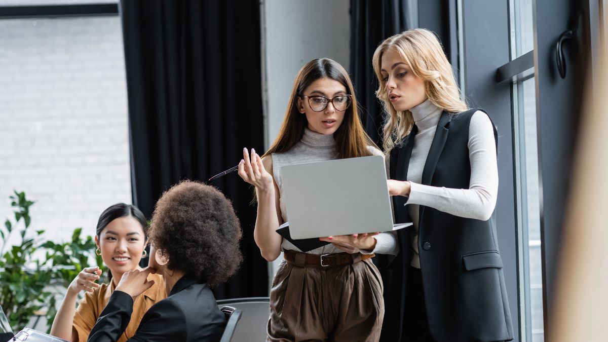women talking with computer at work