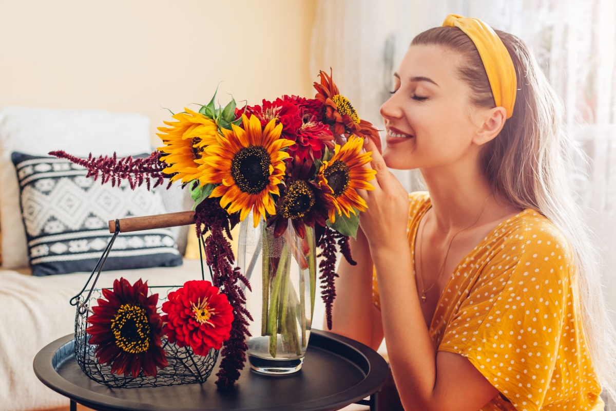 Woman smells bouquet of sunflowers