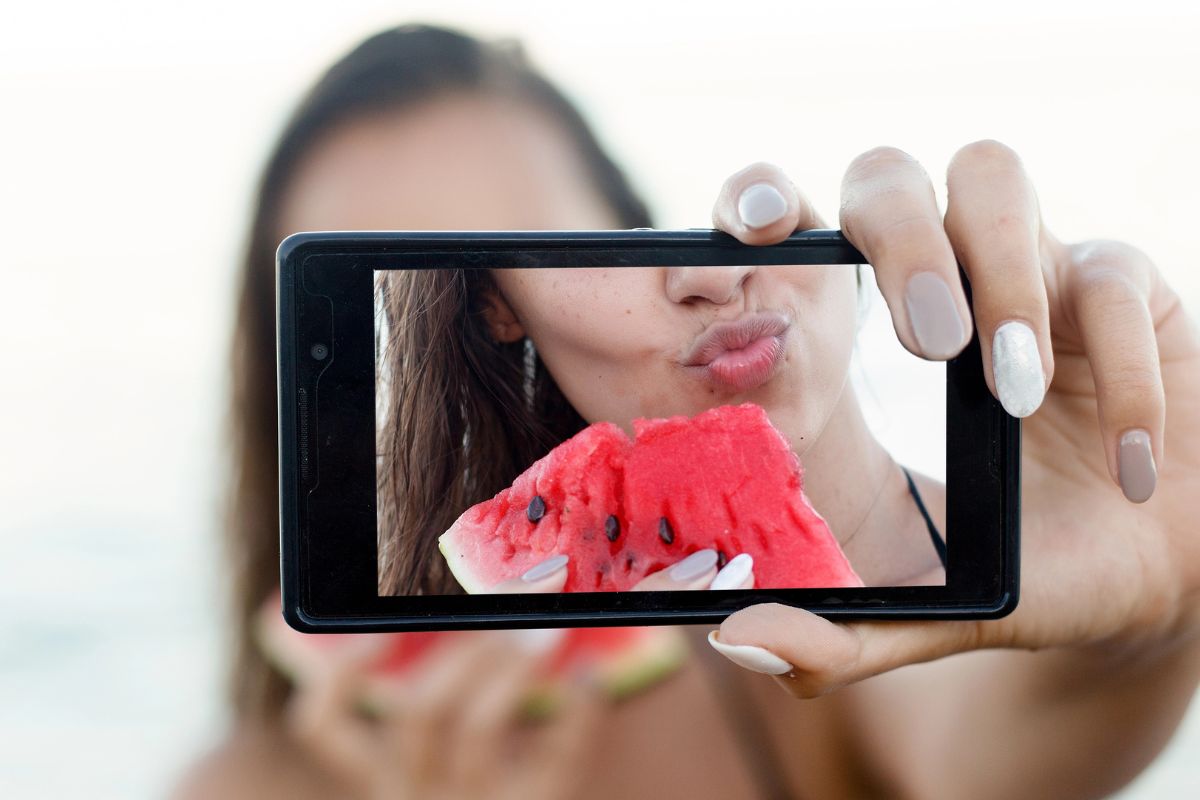 Woman taking a selfie eating watermelon